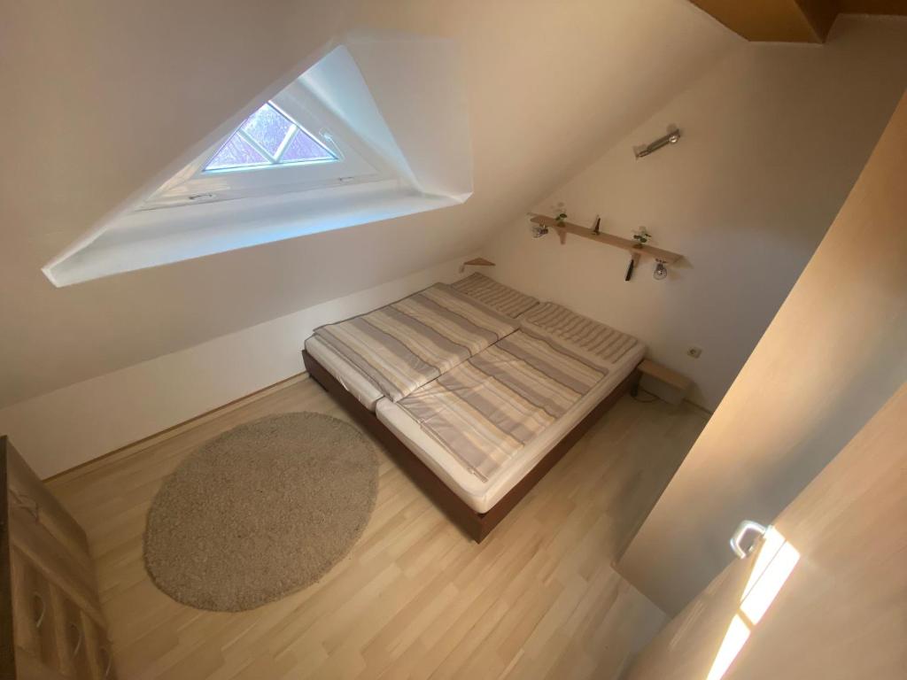 an attic bedroom with a bed and a window at Lüttje Huus Wirdum in Wirdum