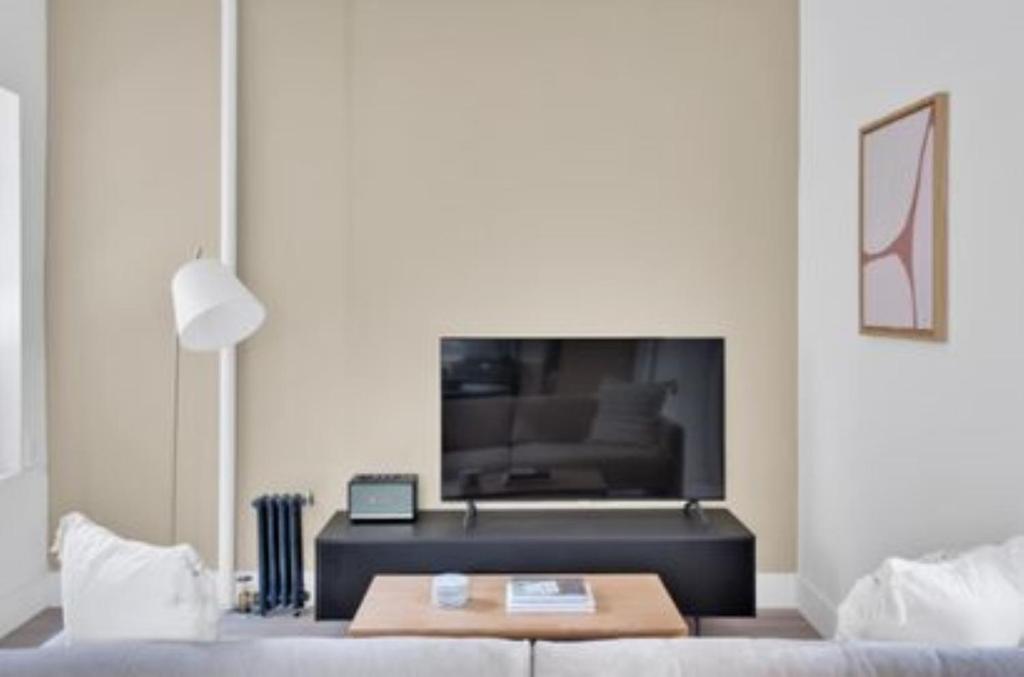 a living room with a couch and a tv at Lovely 3 Bedroom Apartment in New York