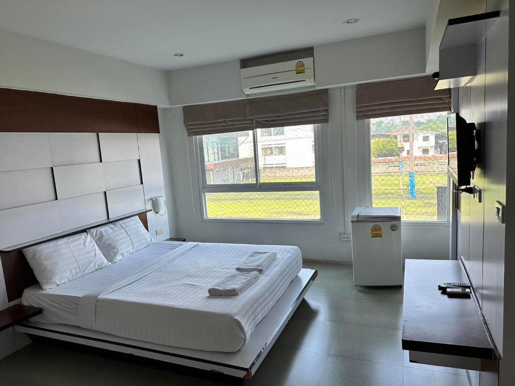 a bedroom with a large bed and two windows at I Garden Place in Ban Choho