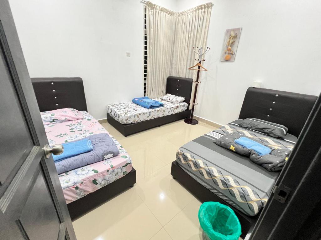 Habitación con 2 camas en una habitación en EMPIRE HOMESTAY PAKA ROOM 3A, en Paka