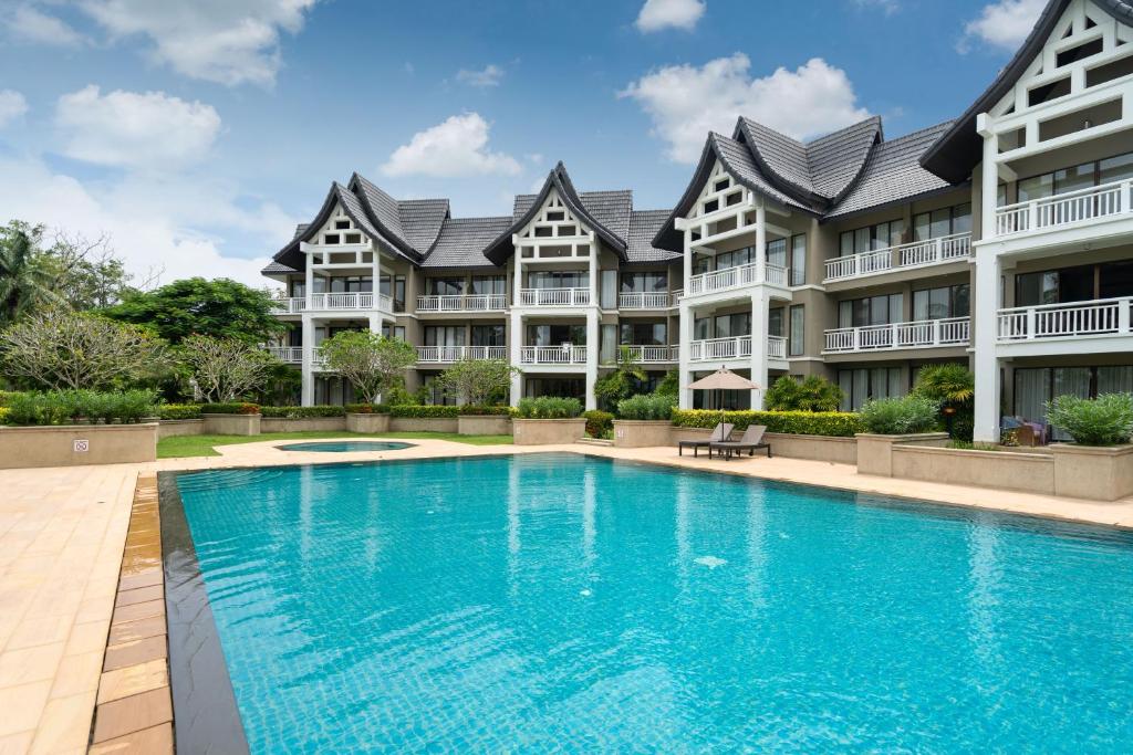 a large apartment building with a large swimming pool at Spacious 2BR Apartment Allamanda II in Laguna, 10 min from BangTao Beach in Bang Tao Beach