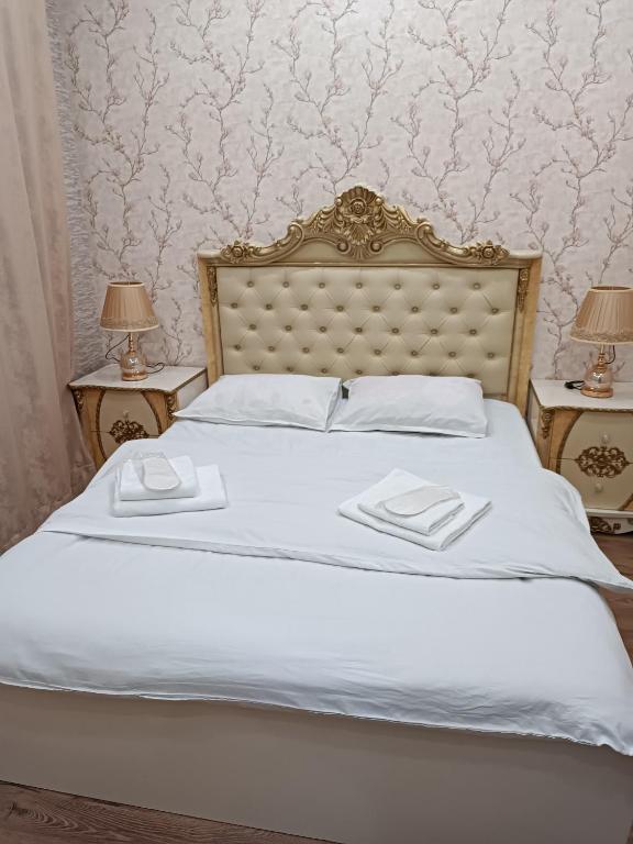 a white bed with two nightstands and two lamps at Tevosyan EVN Airport in Pʼarakʼar