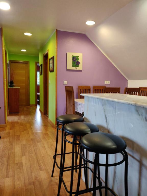 un bar con taburetes en una habitación con paredes coloridas en O Faiado, en Crucero
