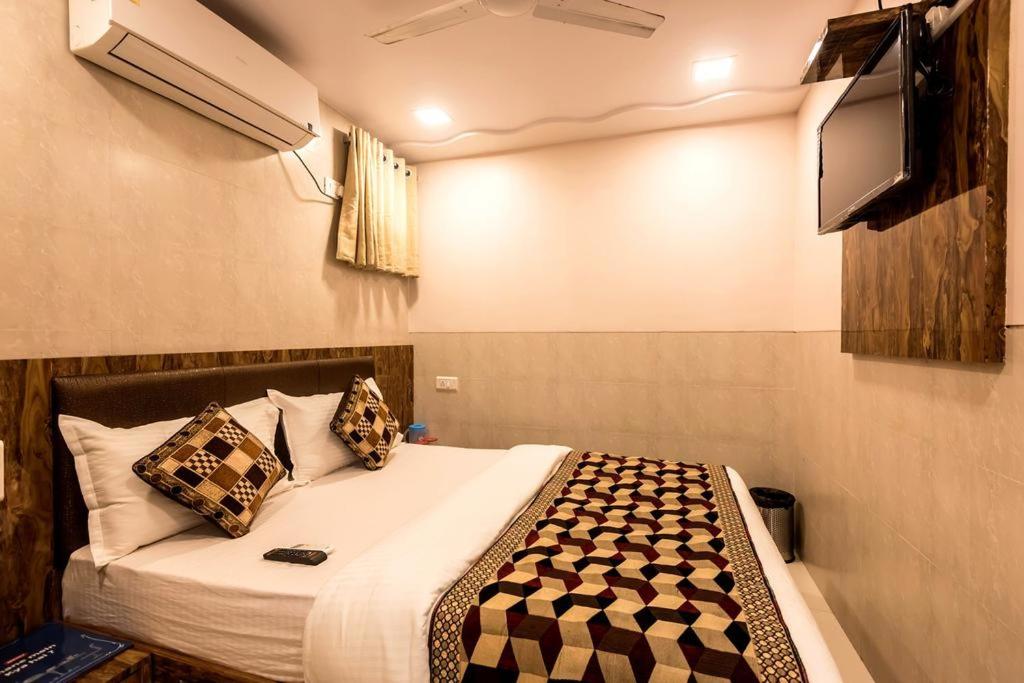a bedroom with a bed and a flat screen tv at Hotel KF Residency in Mumbai