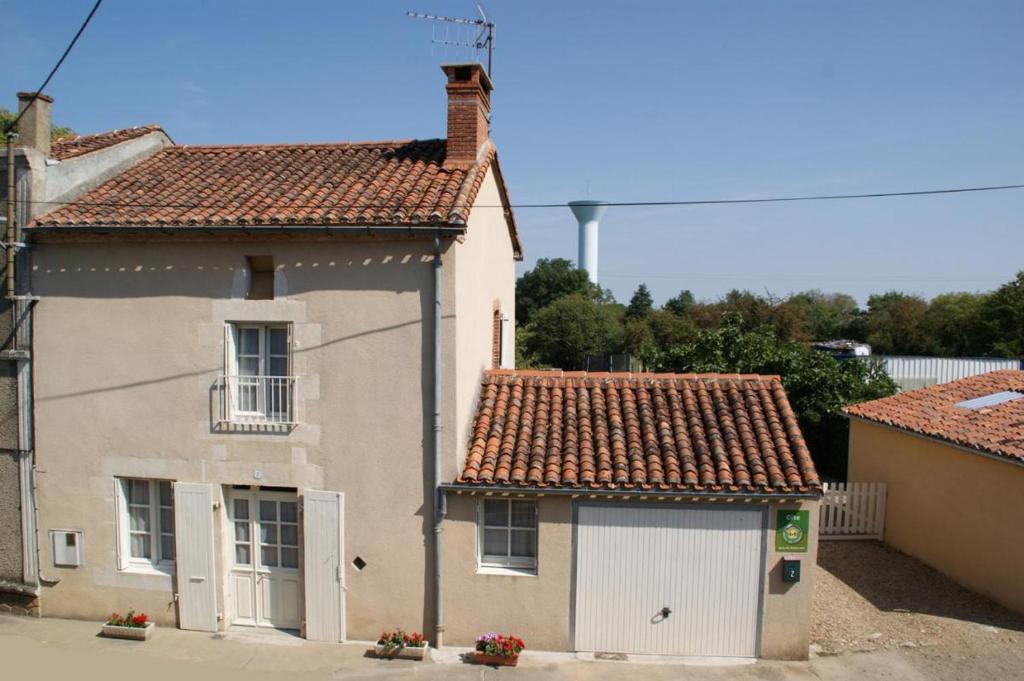 una piccola casa bianca con un garage bianco di Gites de la gartempe : saint-remy a Saint-Rémy-en-Montmorillon
