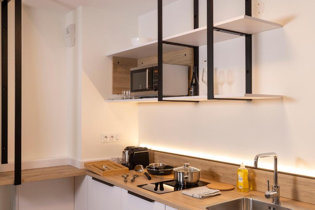 a kitchen with a sink and a stove top oven at Hôtel Du Dragon in Strasbourg