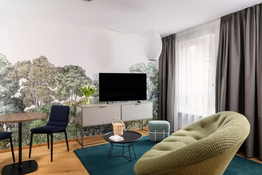 a living room with a tv and chairs at Hôtel Du Dragon in Strasbourg