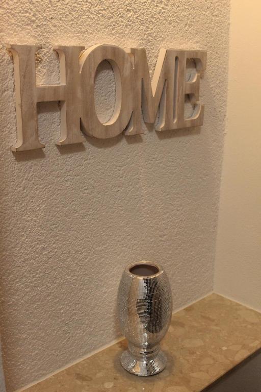 una señal que dice esperanza en una pared con un jarrón en Welcome-Home-Radeberg, en Radeberg