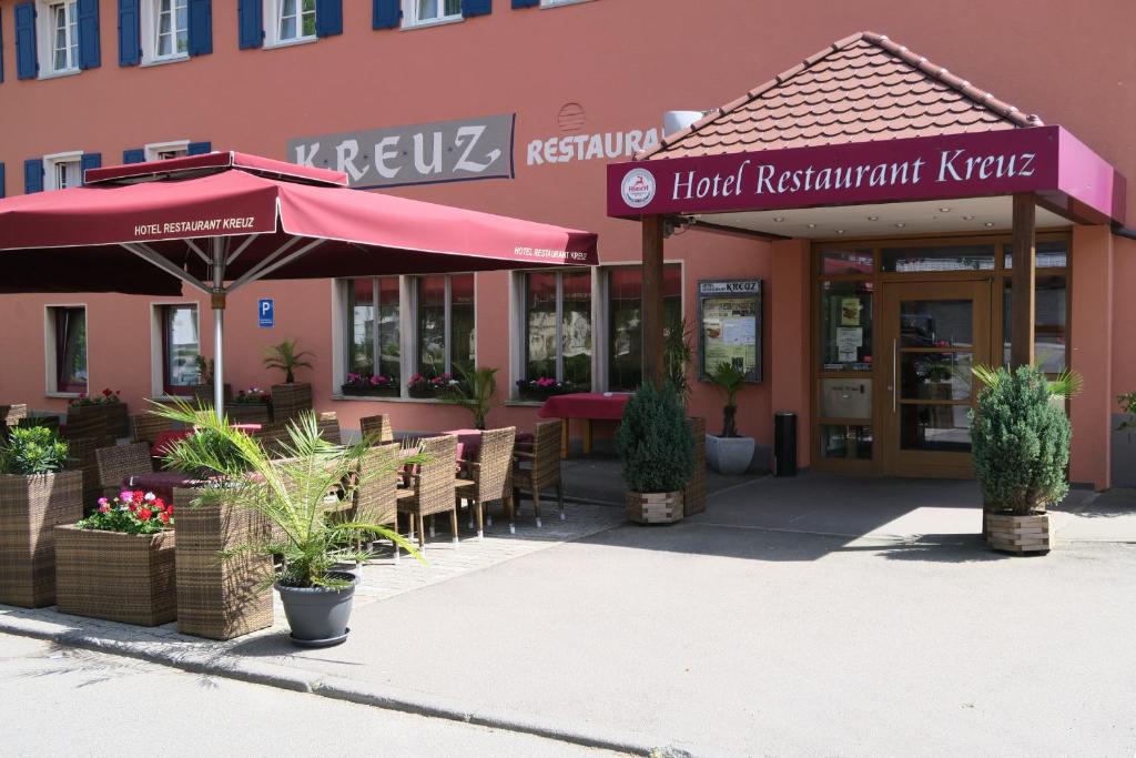 a restaurant with tables and umbrellas in front of a building at Hotel Restaurant Kreuz Spaichingen in Spaichingen