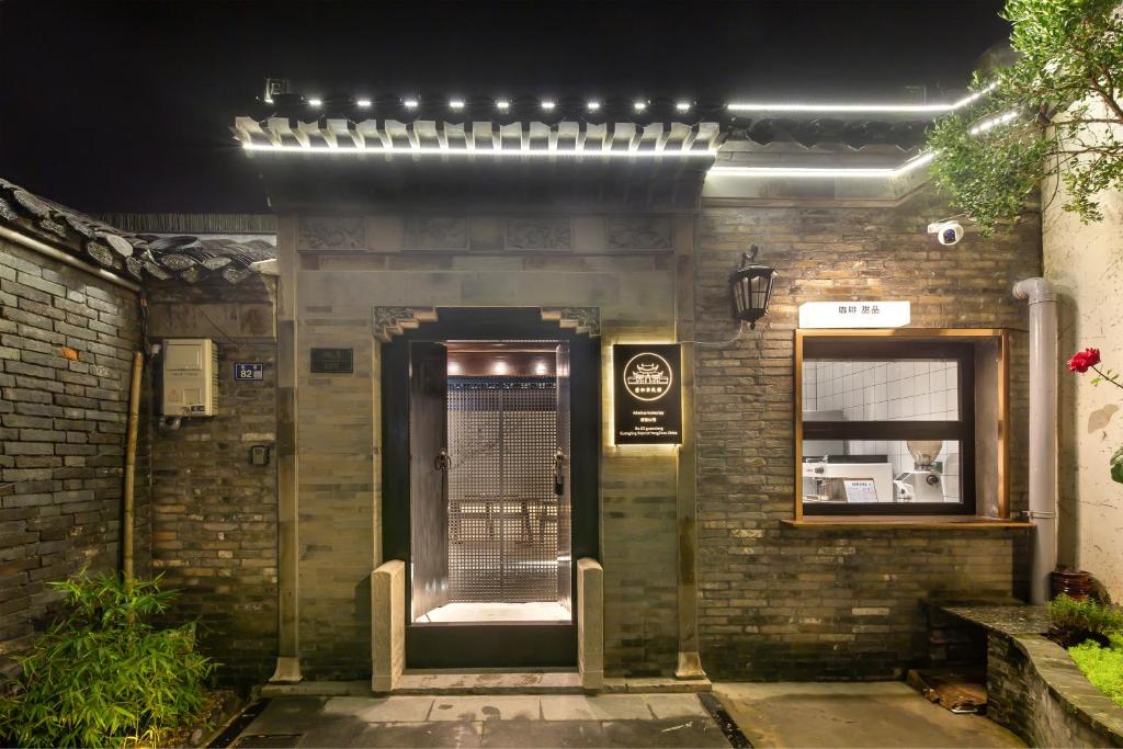 een bakstenen gebouw met een deur met verlichting erop bij Yangzhou Aihehua Boutique Homestay in Yangzhou