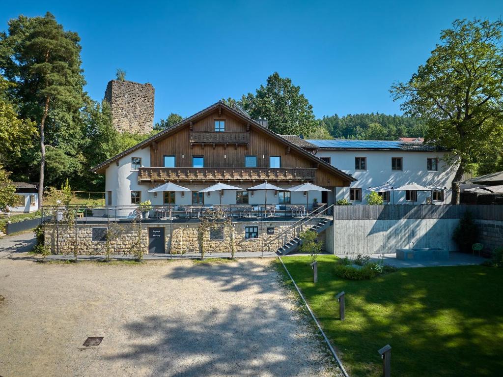 een groot huis met een hek ervoor bij Gasthaus Am Ödenturm in Chammünster