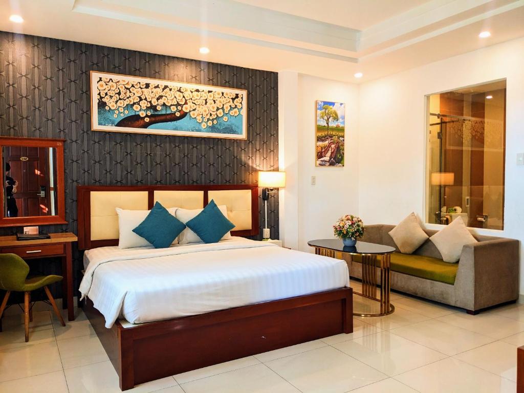 een hotelkamer met een bed en een bank bij Airport Saigon Hotel - Gần ẩm thực đêm chợ Phạm Văn Hai in Ho Chi Minh-stad