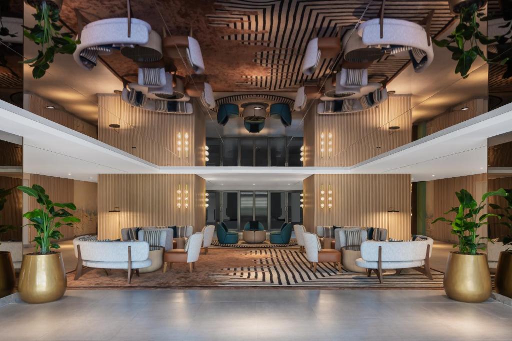 a lobby of a hotel with chairs and tables at Delta Hotels by Marriott Dubai Investment Park in Dubai