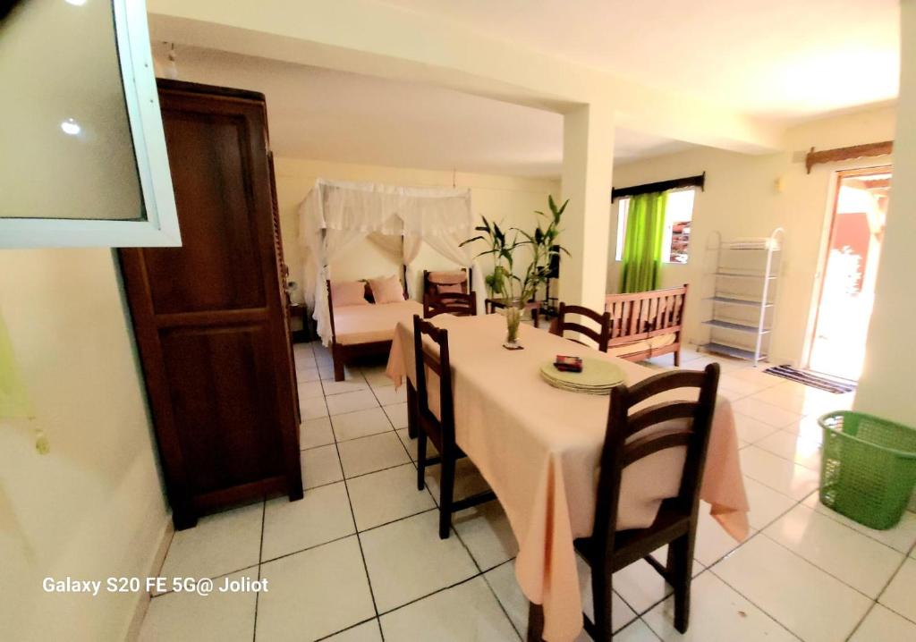 a dining room with a table and a bedroom at LA MARINA 2 in Ambodifototra