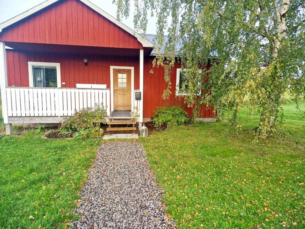 a red house with a pathway in front of it at Litet hus på gård med utsikt över indalsälven in Indal