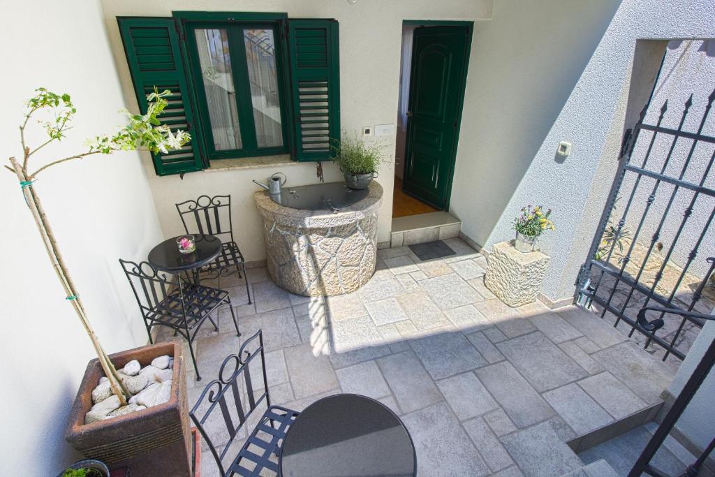 un patio con sedie e lavandino in una casa di Apartments Baška a Baška
