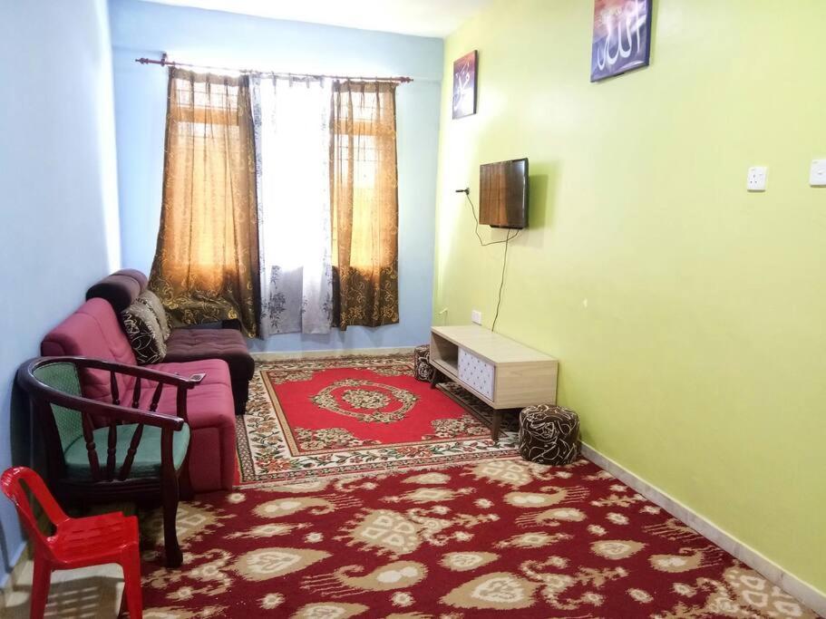 uma sala de estar com um sofá e uma cadeira em Homestay Abah Wakaf Che Yeh em Kota Bharu