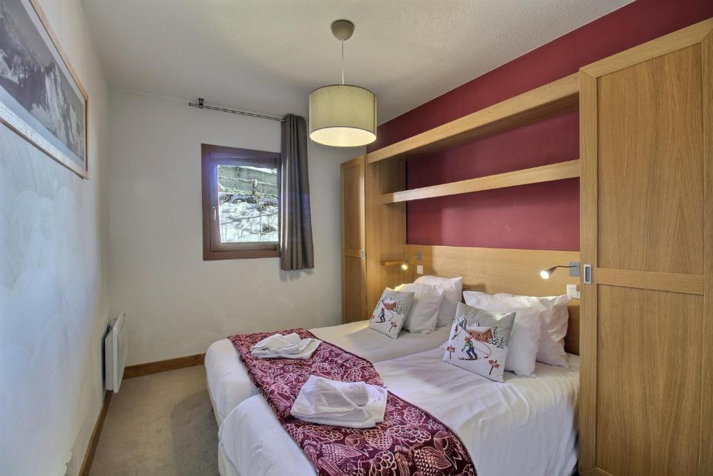 a hotel room with a bed and a window at SAINTE-FOY STATION - APPARTEMENT 6 PERSONNES - SKIS AUX PIEDS in Sainte-Foy-Tarentaise