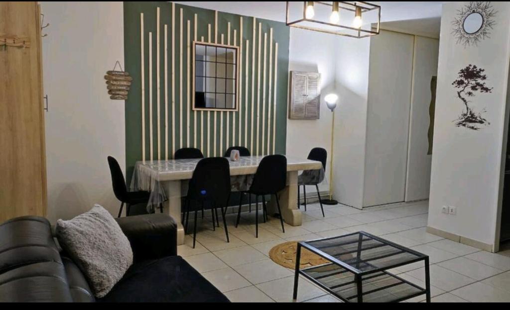 a living room with a dining room table and chairs at Maison de ville proche Le Portel 2 chambres in Outreau
