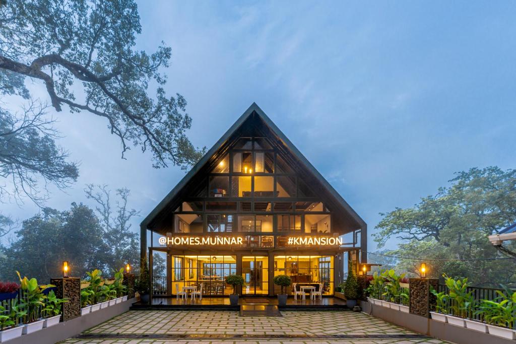 una casa grande con techo de gambrel en K Mansion en Munnar