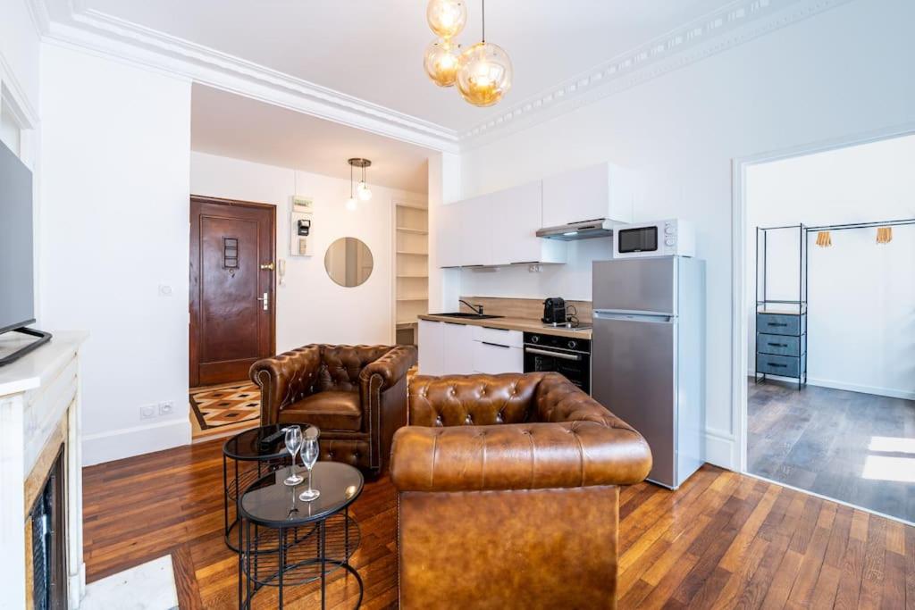 un salon avec deux canapés en cuir et une cuisine dans l'établissement Proche hyper-centre, wifi fibre, lave-linge, à Grenoble