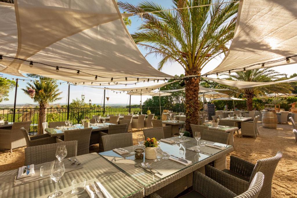 a restaurant with tables and chairs and umbrellas at Château Les Carrasses in Capestang