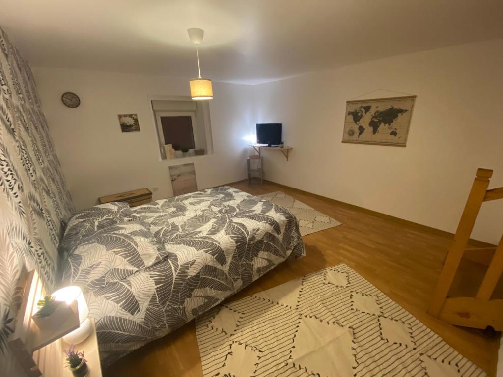 een slaapkamer met een bed en een houten vloer bij chambres de l'étang de la Demoiselle in Saint-Nabord