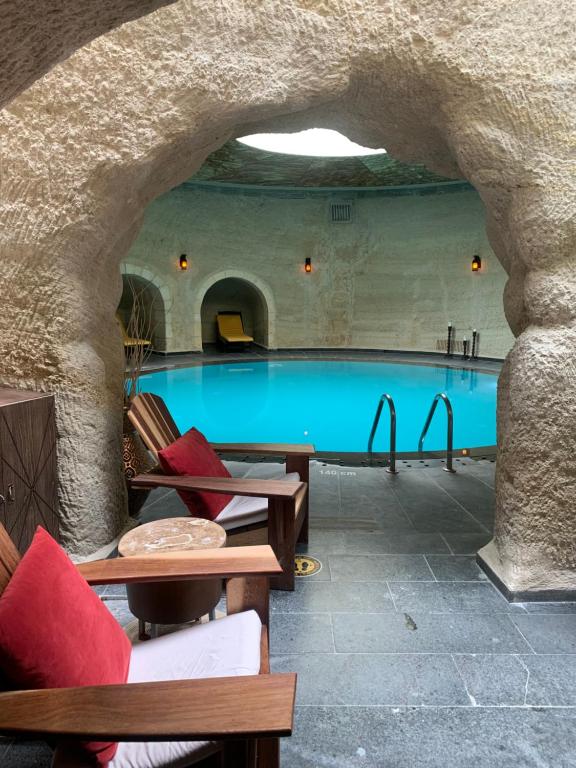 a large swimming pool with chairs and a table at Utopia Cave Cappadocia in Urgup