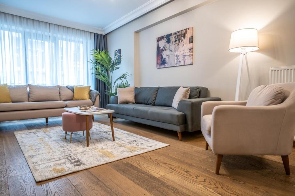 a living room with two couches and a table at Nianta 1-bedroom Near Osmanbey Metro in Istanbul