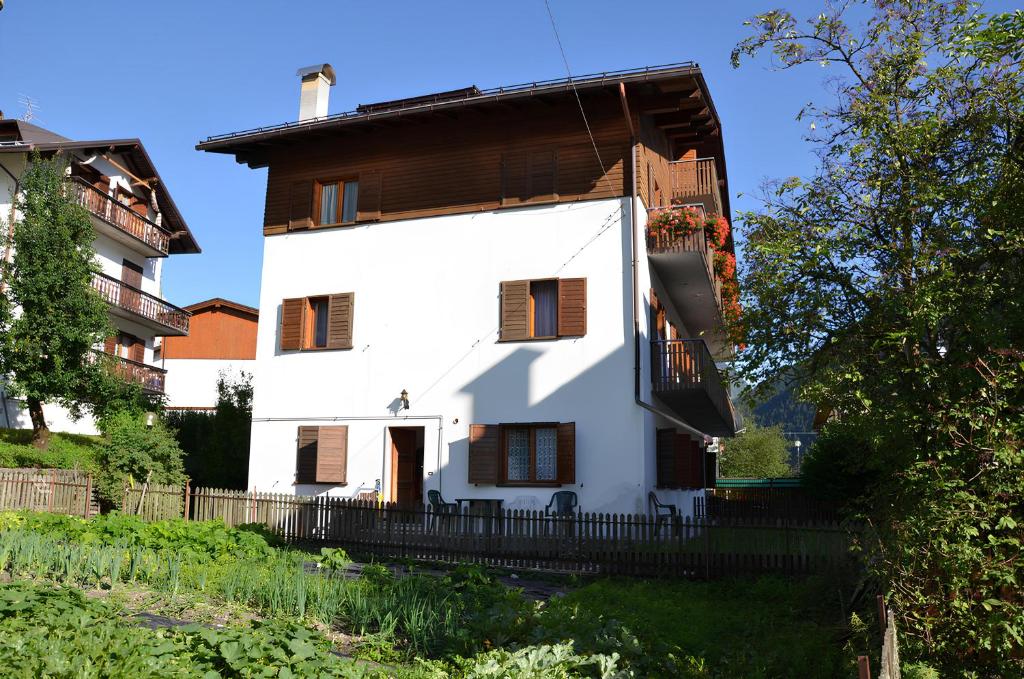 une maison blanche avec un toit en bois dans l'établissement Casa Da Rin Elena, à Auronzo di Cadore