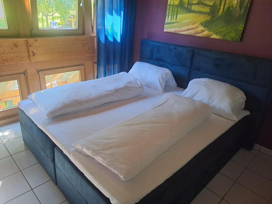 ein großes Bett mit weißer Bettwäsche und Kissen darauf in der Unterkunft Theox No 12 I 5 Personen I Bibliothek I Badwanne in Heppenheim an der Bergstrasse