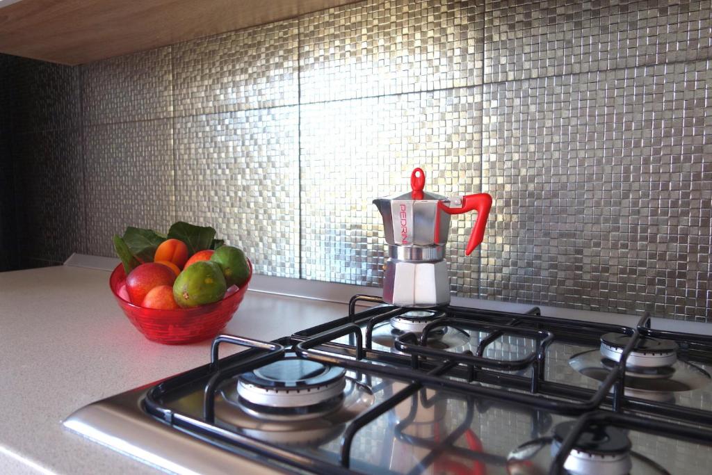 a kitchen stove with a bowl of fruit on the counter at Eolo Casa Vacanze in Torre Lapillo
