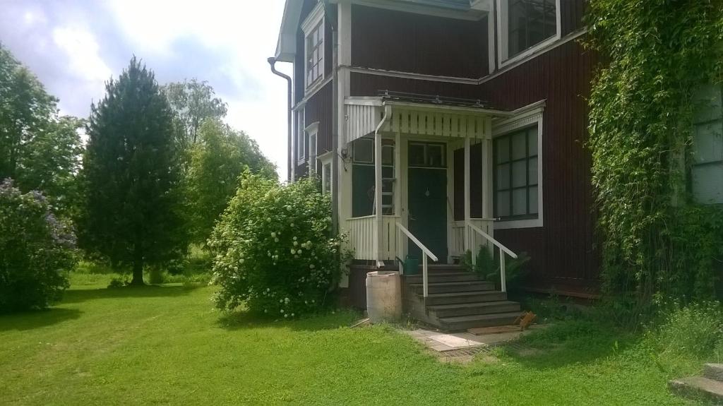 une maison rouge avec une porte verte sur une cour dans l'établissement Suvannonrannan Majoitukset, à Kauhajoki