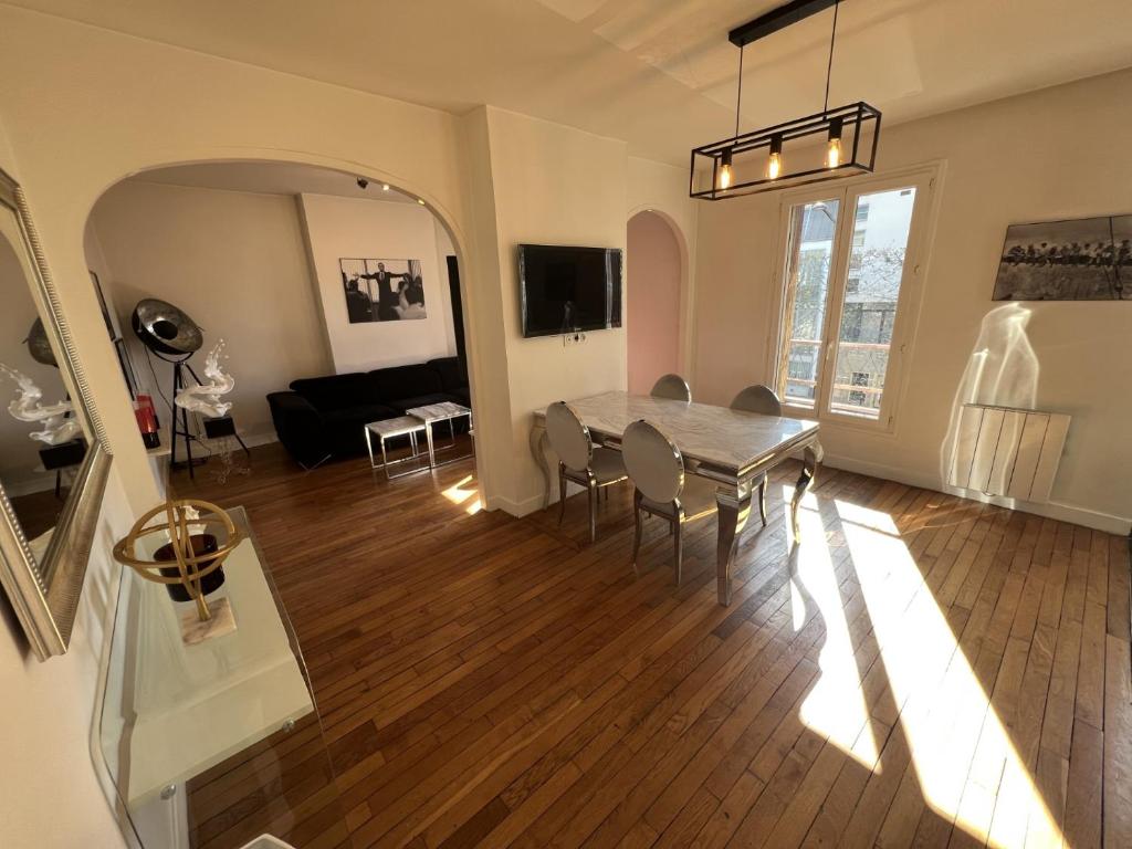 sala de estar con mesa y sofá en Beau 3 pièces aux portes de PARIS, en Charenton-le-Pont