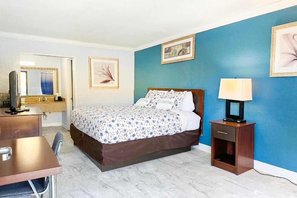 a bedroom with a bed and a blue wall at Paradise Inn By OYO Hattiesburg North in Hattiesburg