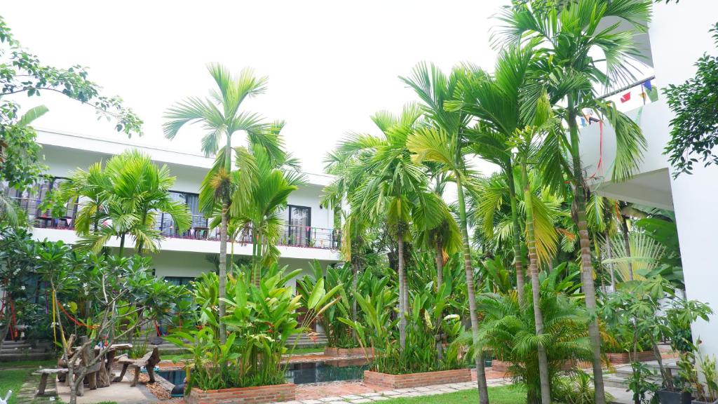 un edificio con palmeras delante en Villa Zoneast, en Siem Reap