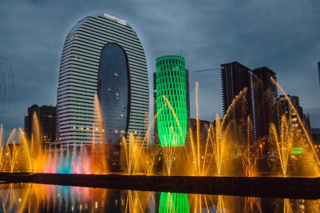 a fountain in front of a city with tall buildings at Sunshine Apartments Batumi Lux in Batumi