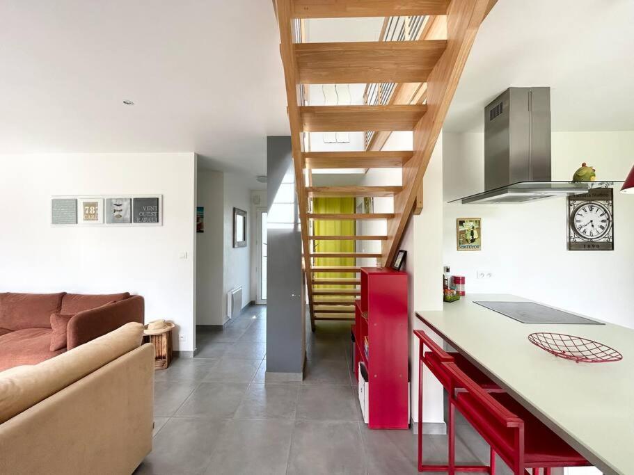 une cuisine et un salon avec un canapé et une table dans l'établissement Maison de charme, Les Voiles à Sainte Marine, à Combrit