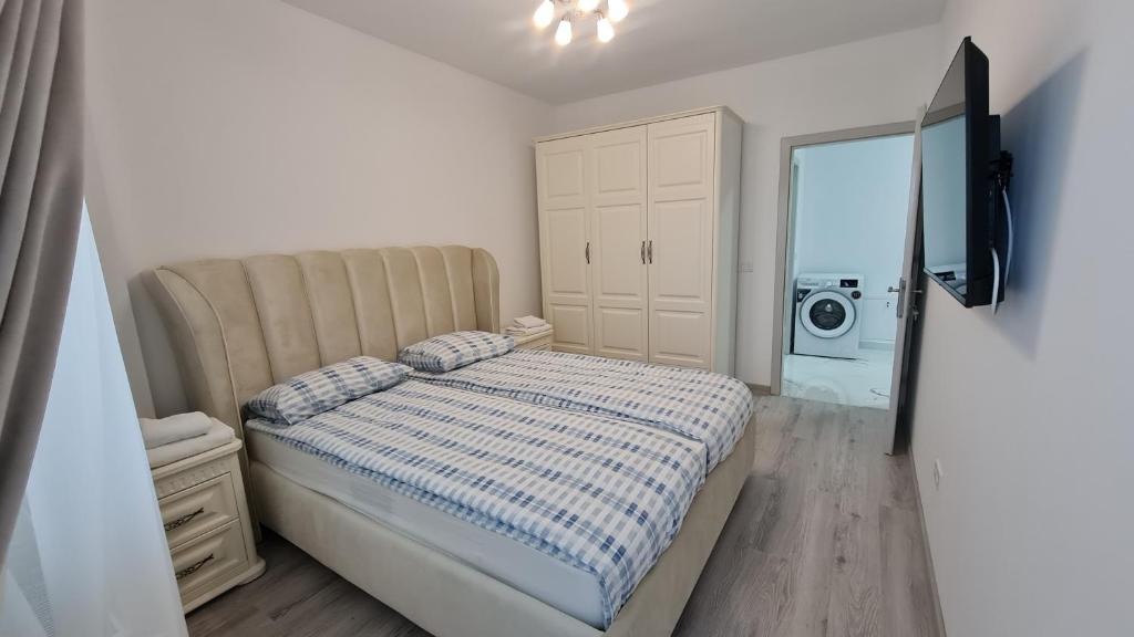 a bedroom with a bed and a dresser and a washing machine at NORDIC Residence 3 in Suceava