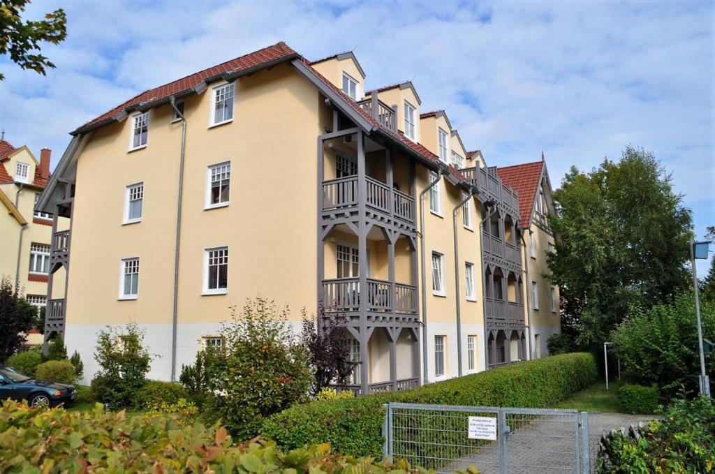 un grand bâtiment jaune avec balcon. dans l'établissement Haus Ostseewelle Wohnung Nr. 2, à Kühlungsborn