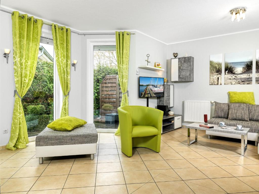 a living room with a green chair and a couch at FH Harmonie in Kaltenhof