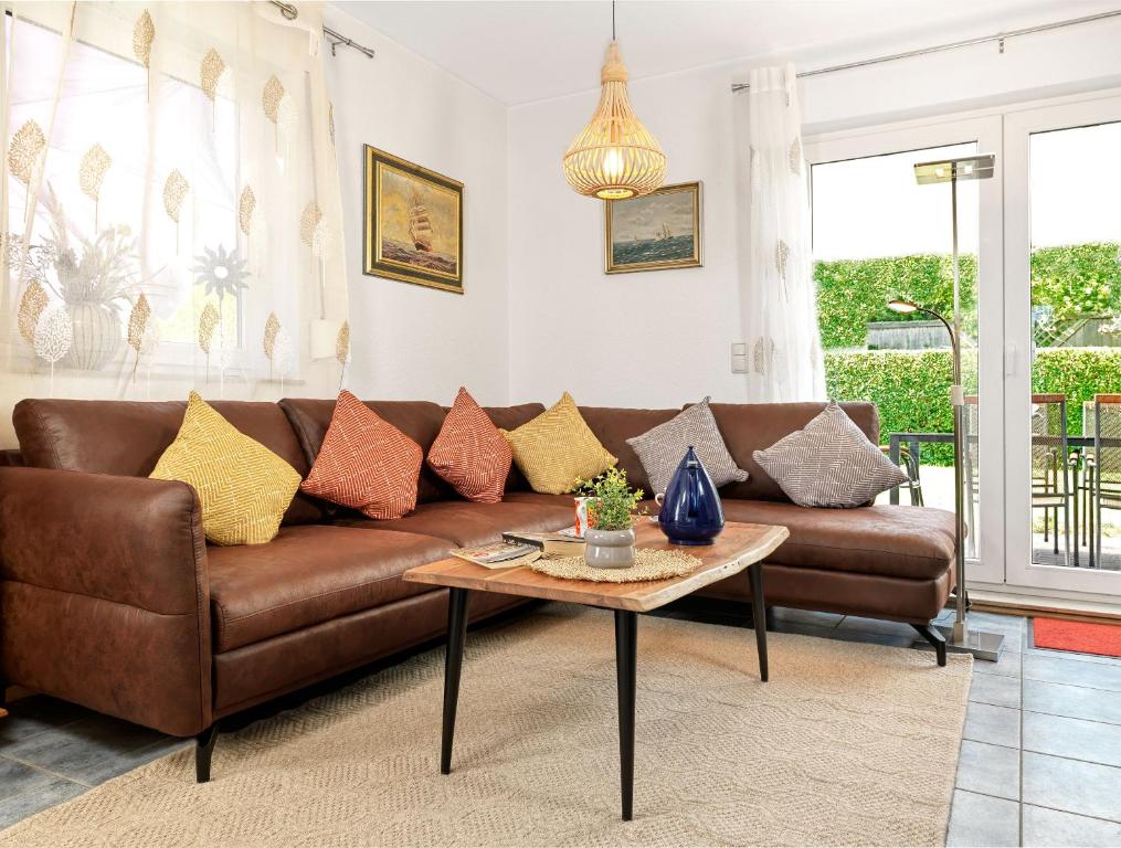 a living room with a brown couch and a table at Haus Sonneneck in Kaltenhof