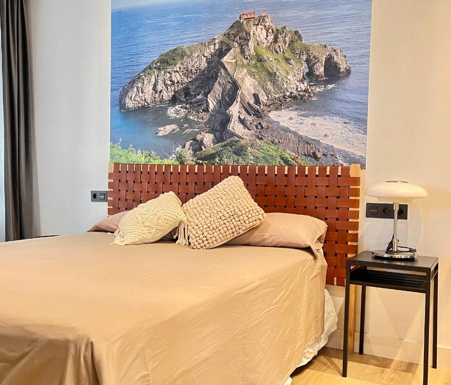 a bedroom with a bed with a painting on the wall at SMALL LUX BEACHCITY CLOSE to the RIVER,METRO AND PARKING in Bilbao