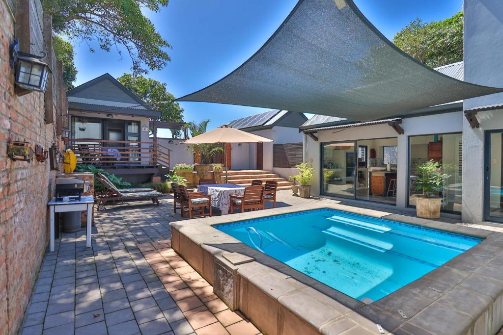 - une piscine dans une arrière-cour avec une maison dans l'établissement Relaxation, à KwaDukuza