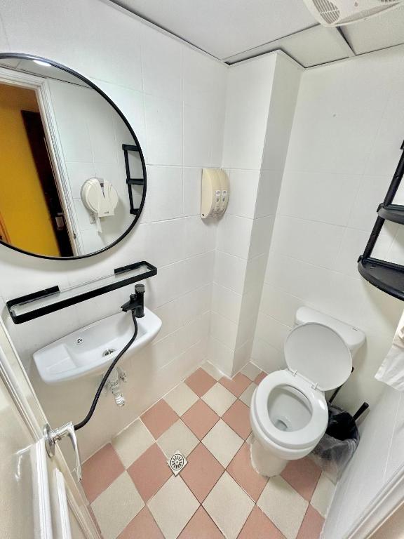 a bathroom with a toilet and a sink and a mirror at Taipei Triple Tiger Inn in Taipei