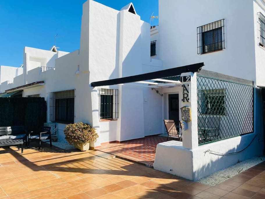 a white house with a patio and a fence at Acogedora casa con terraza y chimenea in Marbella
