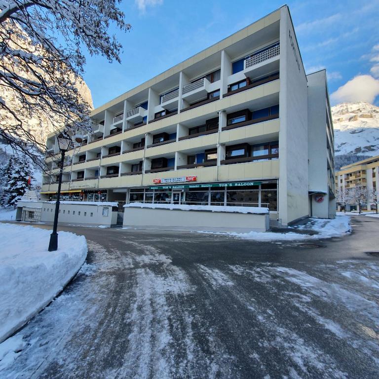 a large building with a snow covered street in front of it at Fortuna 403 in Leukerbad