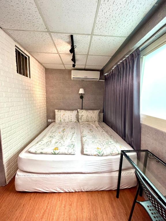a large bed in a room with a window at Taipei Triple Tiger Inn in Taipei