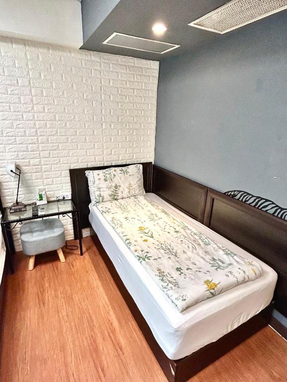 a bedroom with a bed and a side table at Taipei Triple Tiger Inn in Taipei