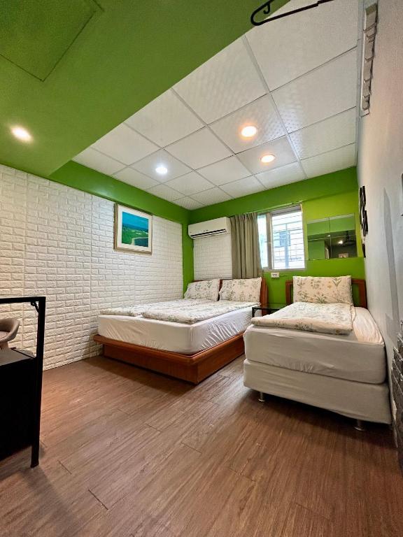 two beds in a room with green walls at Taipei Triple Tiger Inn in Taipei